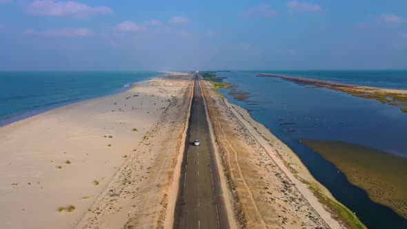 Driving on a scenic route surrounded by sea - drone view of dhanushkodi