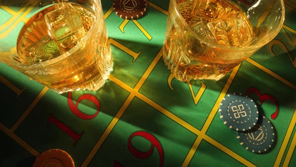 Top View of Green Casino Table with Glasses of Whiskey and Chips