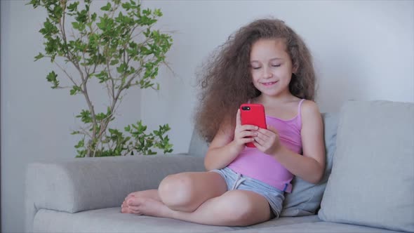 Cute Little Girl Preschool Child Using a Digital Tablet Technology Device Looks telephone.Plays in