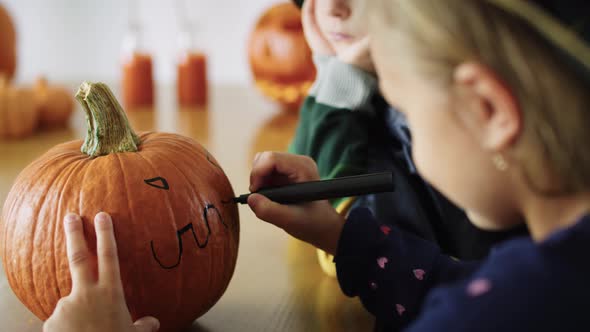 Close up of girl drawing on pumpkin