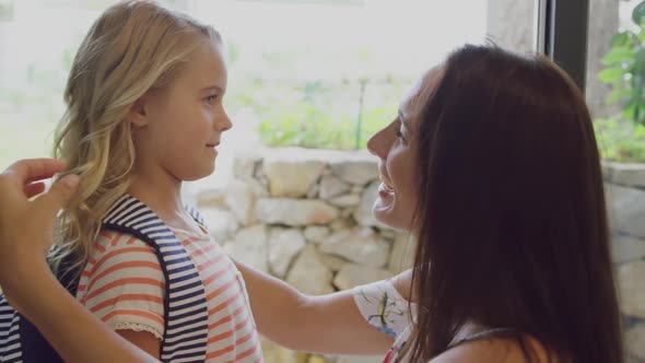 Daughter embracing her mother before leaving school at door in home 4k