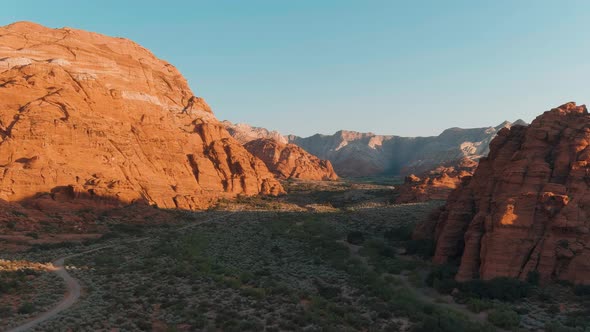 Wide aerial shot pushing through Snow Canyon's vast arid landscape.