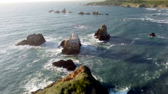 Drone shot. Push in on rocky cove at sunset. 4k 24fps.