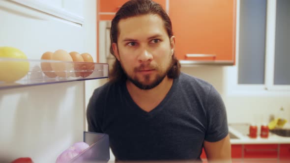 Man Opens Fridge Door Looks Inside Takes Out Vegetables