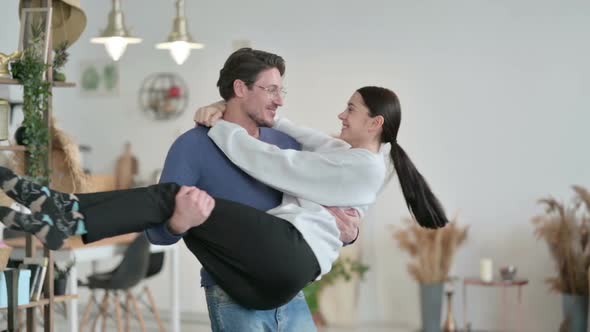 Man Moving in Circle While Holding Woman in Arms