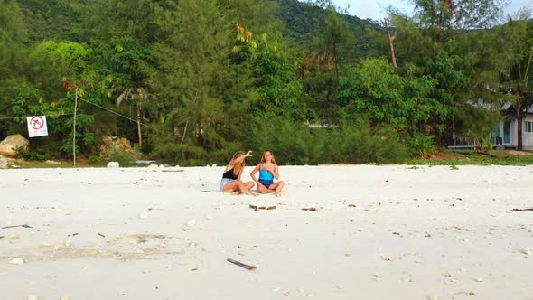 Ladies posing on perfect bay beach wildlife by blue water with white sandy background of Thailand ne