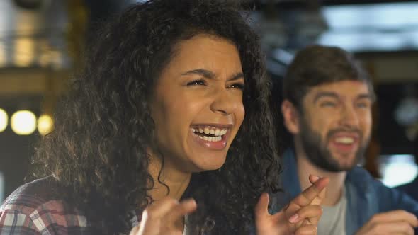 Friends Crossing Fingers for Good Luck, Cheering for Sports Team Victory in Pub