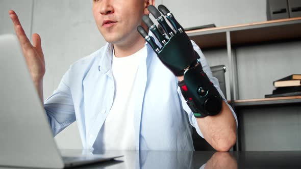 Programmer freelancer man with bio hand prothesis talks at online video