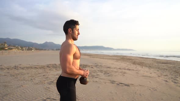 athlete training on the beach with kettlebell and sea view