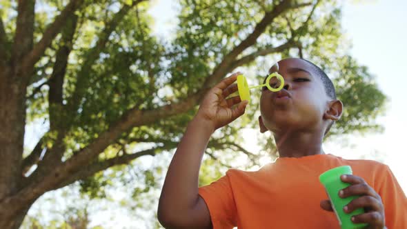 Young boy blowing bubbles through bubble wand