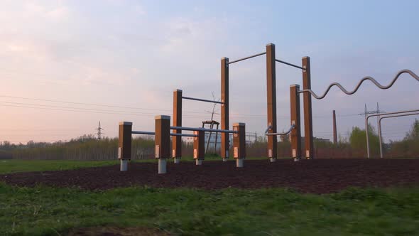 A Camera Passes By a Outdoor Gym During a Sunrise. Footage From Left To Right