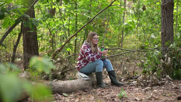 Wide Shot Beautiful Landscape in Forest with Young Woman Drinking Water From Thermos in Slow Motion