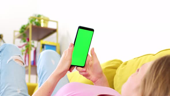Rear View of Phone with Green Screen Chroma Key in Hands of Blonde in Pink Top