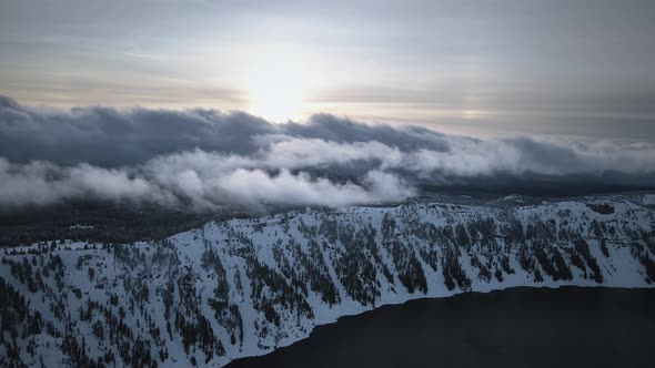 Aerial video of Crater Lake snowy shore covered with snow and trees, Oregon