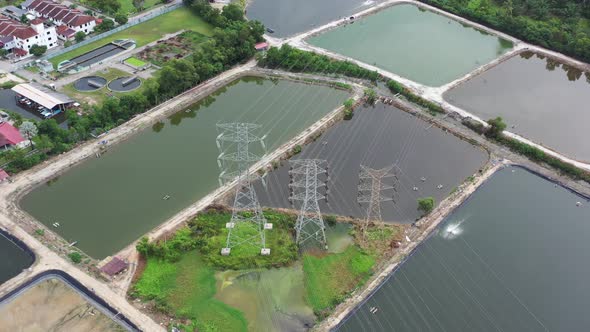 Drone fly around outdoor aquaculture farming controlled facility with transmission tower in the midd