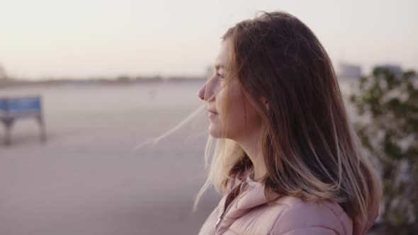 Young Woman Observes Sunset at the Ocean