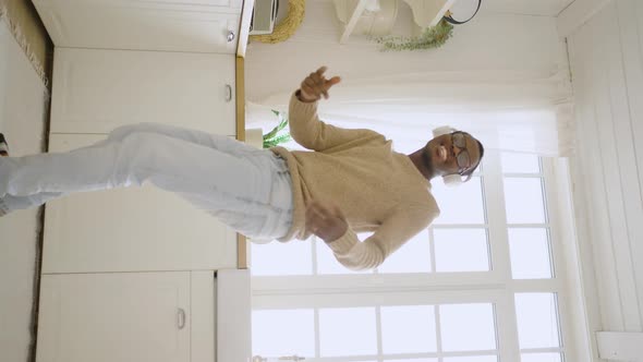 Happy Man Dances Listening Favorite Song in Modern Kitchen