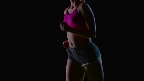 Woman in Shorts and Top Runs Beautifully on a Black Screen. Slow Motion. Close Up