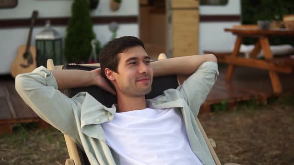 Pleased Handsome Caucasian Man Chilling Out While Laying on Summer Bed Outdoors