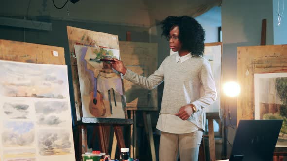 African Ethnicity Lady is Explaining a Painting During an Online Art Lesson