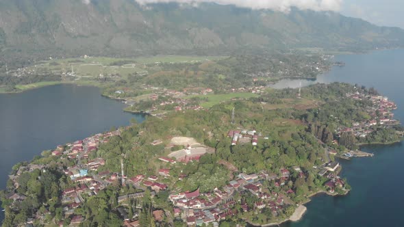 Aerial: flying over lake Toba and Samosir Island Sumatra Indonesia. Tuk Tuk traditional village and