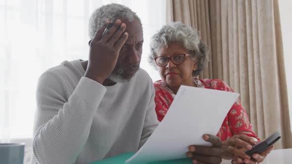 A senior african american couple spending time together at home working on papers. social distancing