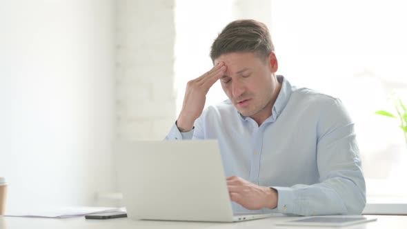 Man having Headache while Working on Laptop