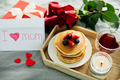 Wooden tray with delicious breakfast - syack of pancakes, tea, present, roses and burning candle - PhotoDune Item for Sale