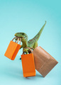 Cute green dinosaur with shopping bags on a blue background. Cute humor shopping concept. - PhotoDune Item for Sale