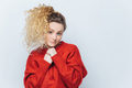 pleasant looking young female with curly light pony tail, dressed in red sweater - PhotoDune Item for Sale