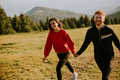 Smiling couple walking over green hills - PhotoDune Item for Sale
