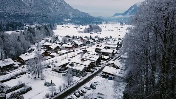 Aerial sliding view of Grainau town in a snowy winter. Roofs covered by snow. Bavaria, Germany.