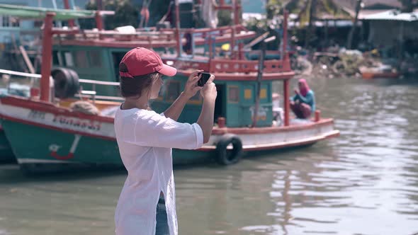 Girl Tourist Shoots Fishing Boats on Phone Backside View