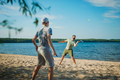 caucasian man and teenager son playing badminton on the lakeside. Parents and teens concept. - PhotoDune Item for Sale