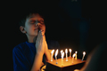 little cute caucasian boy making a wish before puffing out a candle on cake on his 6 birthday - PhotoDune Item for Sale