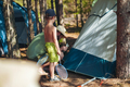 cute little caucasian boy helping to put up a tent. Family camping concept - PhotoDune Item for Sale