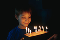 little cute caucasian boy making a wish before puffing out a candle on cake on his 9 birthday - PhotoDune Item for Sale