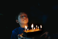 little cute caucasian boy making a wish before puffing out a candle on cake on his 9 birthday - PhotoDune Item for Sale