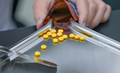 Selective focus on yellow tablets pills on stainless tray with blur hand of pharmacist or pharmacy - PhotoDune Item for Sale