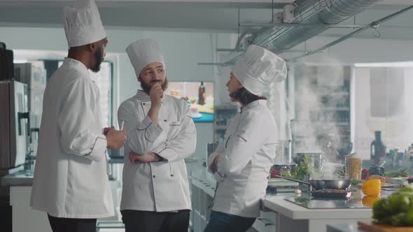 Diverse Team of Chefs Having Conversation About Cooking Dish