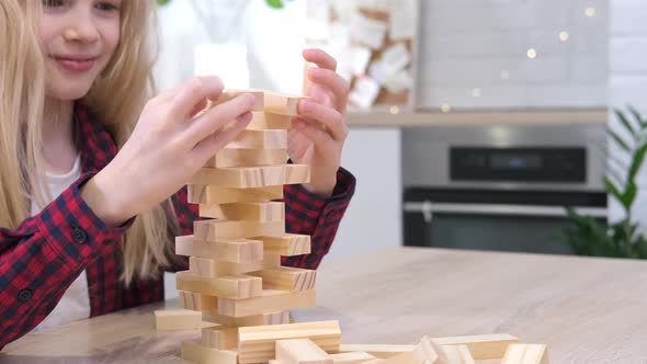 Children Playing Wooden Block Removal Tower Game at Home