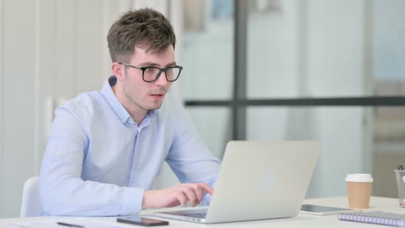 Young Man with Laptop Having Loss Failure