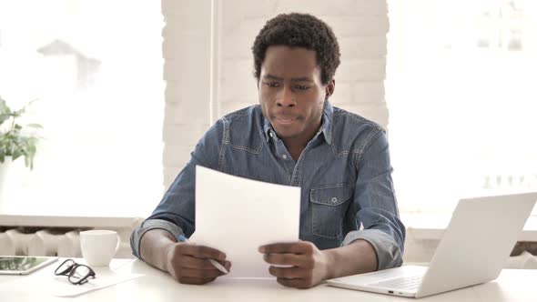 African Man Reading Documents Contract