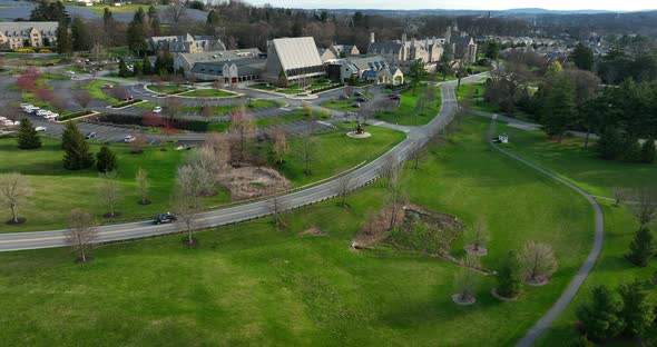 Car drives on road through large estate, retirement community in USA. Aerial in spring.