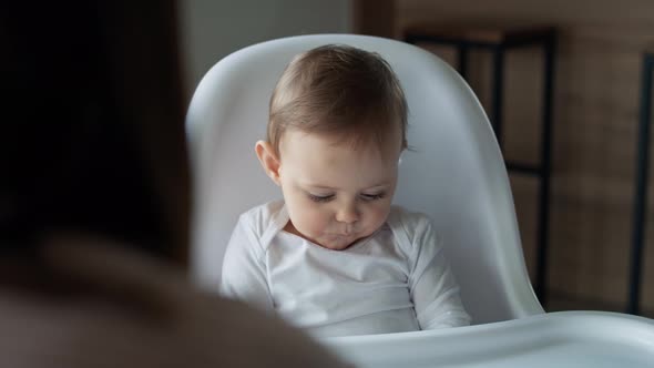 Video of mom feeding baby girl in high chair. Shot with RED helium camera in 8K.