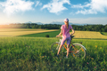 Woman on mountain bike on gravel road at sunset in summer - PhotoDune Item for Sale