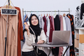 Muslim woman holding credit cards in clothing store. Credit card payment service. - PhotoDune Item for Sale