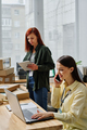Young busy volunteer talking on mobile phone and networking - PhotoDune Item for Sale
