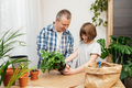 A teenage girl and dad are transplanting a monster houseplant into another pot. Home gardening  - PhotoDune Item for Sale