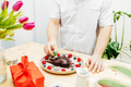  man's hands decorating a chocolate heart cake with a sprig of fresh mint for valentine's day - PhotoDune Item for Sale